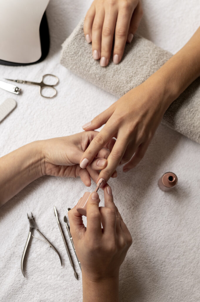 close up manicurist using nail polish